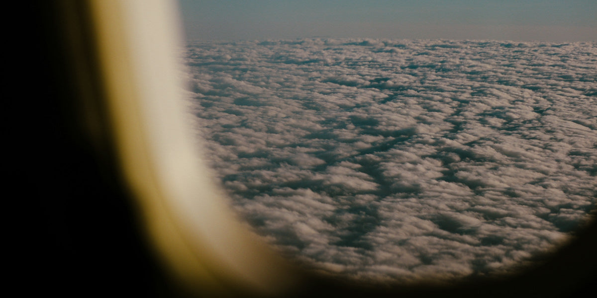 View of soft clouds from an airplane window at cruising altitude