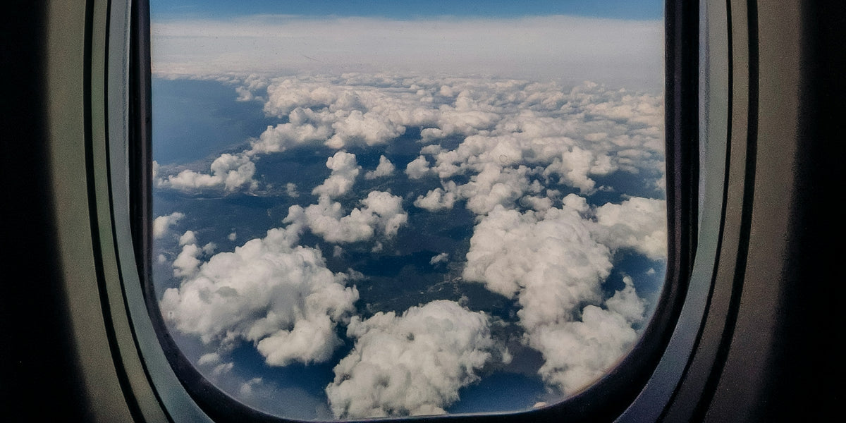 Layered clouds seen through an airplane window at cruising altitude