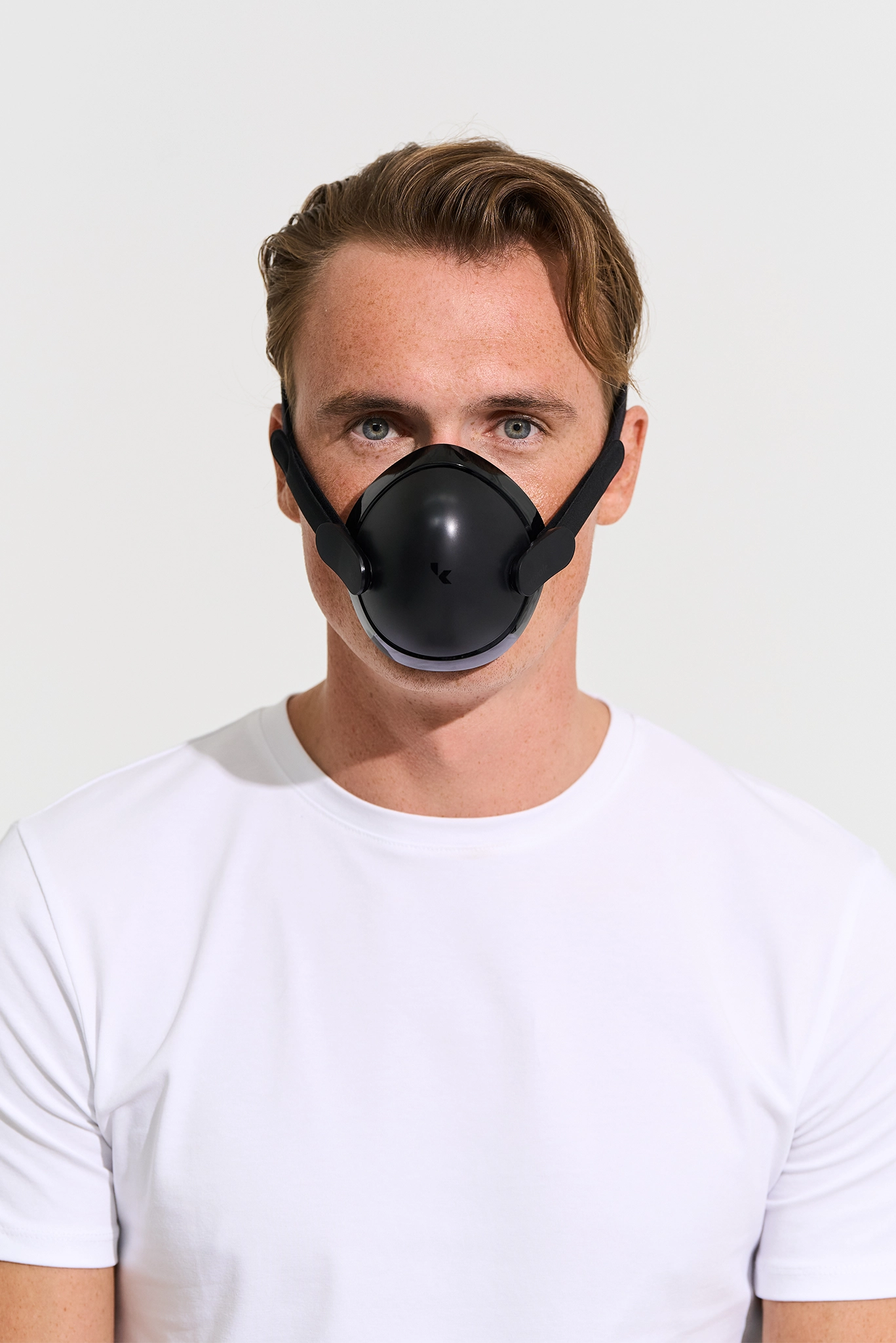 Man wearing a black kuvola face mask against a white background