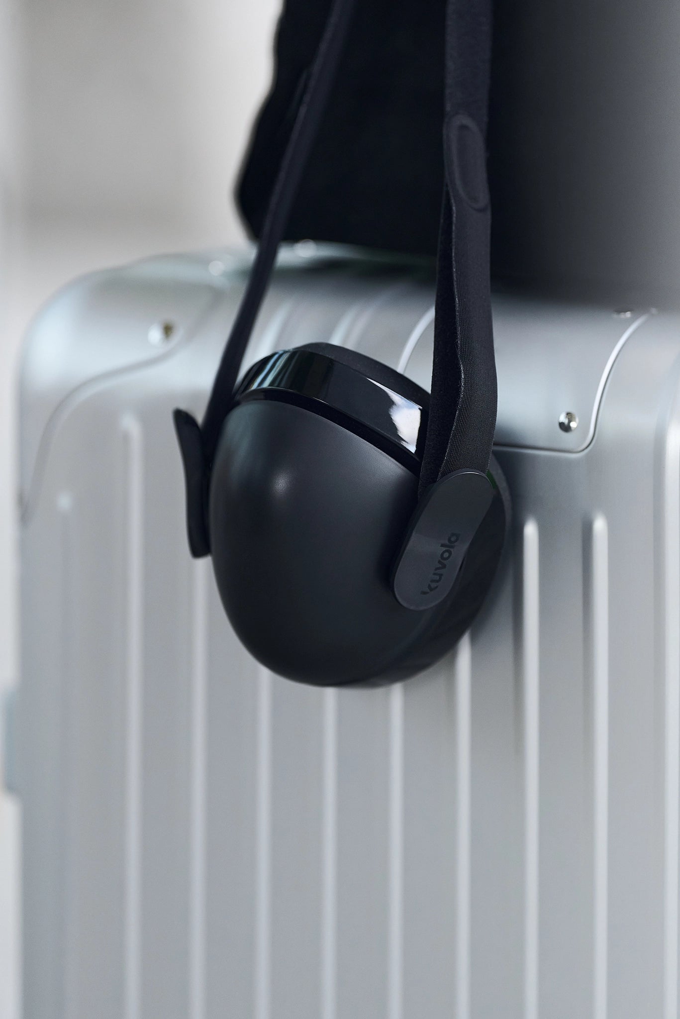 a premium black kuvola humidifier mask attached to a silver suitcase with a blurred background