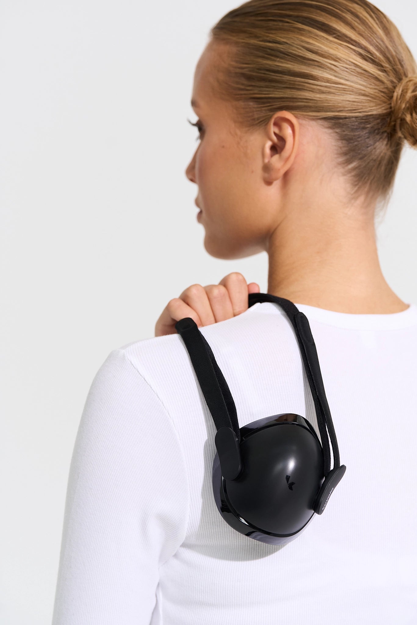 Person wearing a black backpack against a white background