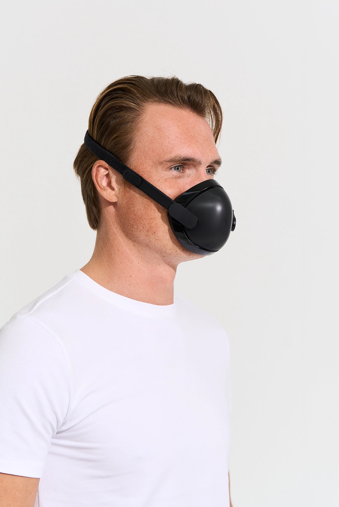 Man wearing a black mask against a white background