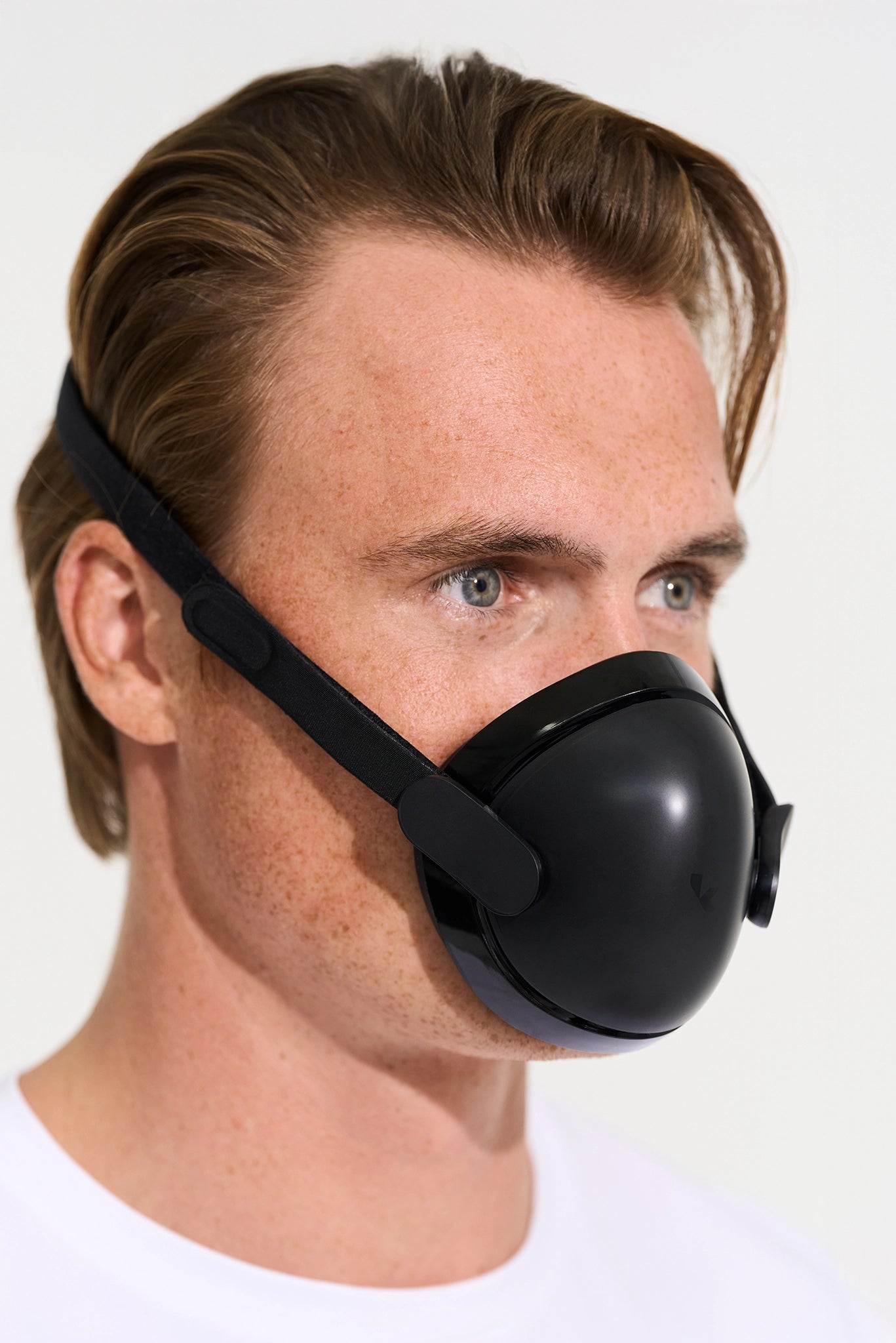 Person wearing a black kuvola jet lag mask on a white background.
