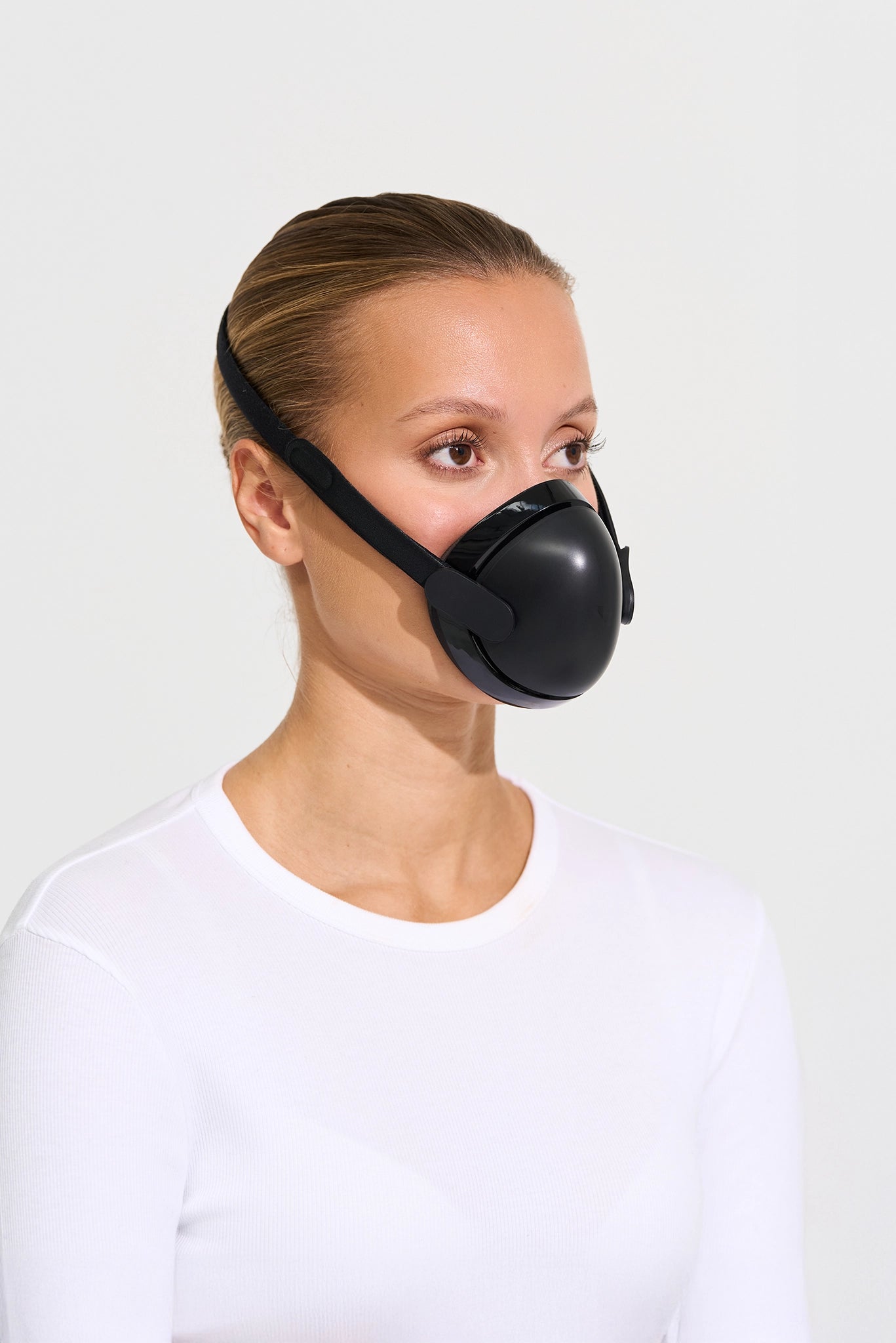 Person wearing a black face mask on a white background
